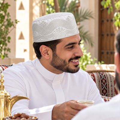 رجل يرتدي طاقية مطرّزة بيضاء في مجلس